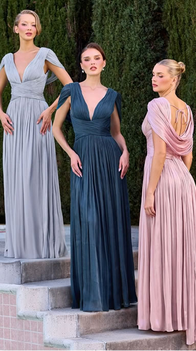 Three women in floor-length gowns posing on stone steps outdoors; left light gray, center blue, right pink.
